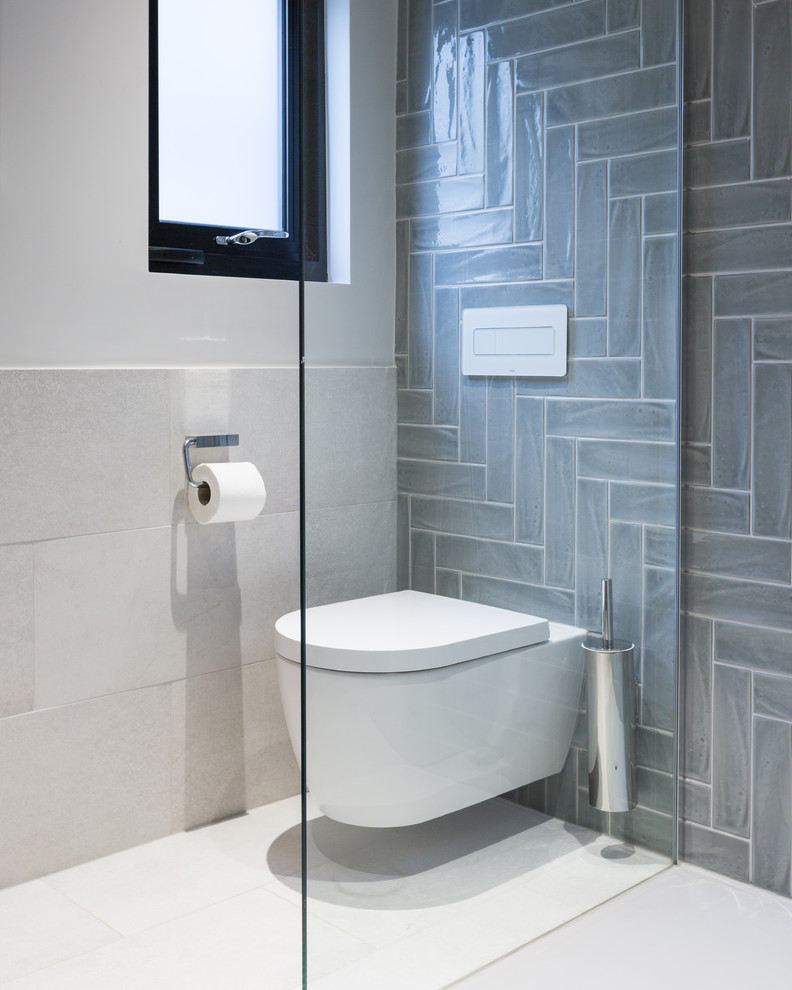 Inspiration for a small contemporary master bathroom in Gloucestershire with furniture-like cabinets, an open shower, a wall-mount toilet, gray tile, porcelain tile, white walls, porcelain floors, an integrated sink, grey floor, an open shower, grey cabinets, solid surface benchtops and white benchtops.
