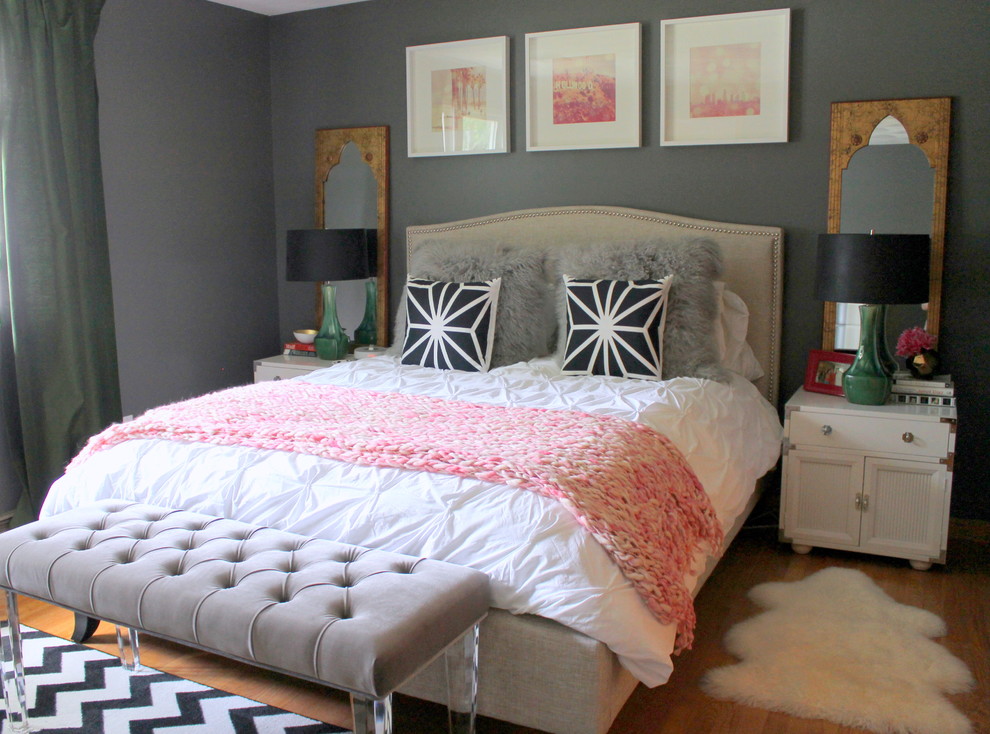 Photo of a mid-sized eclectic master bedroom in Kansas City with grey walls and medium hardwood floors.