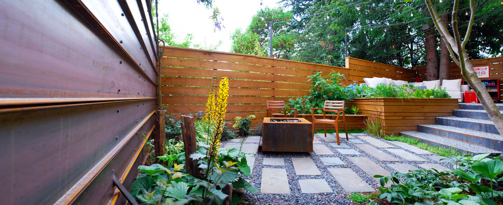 This is an example of a small modern backyard partial sun garden for summer in Seattle with a vegetable garden and natural stone pavers.
