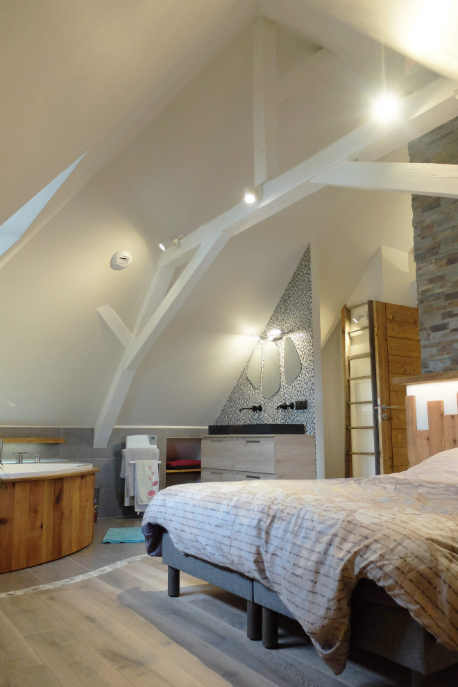 Modernes Schlafzimmer mit Kaminumrandung aus gestapelten Steinen und freigelegten Dachbalken in Straßburg