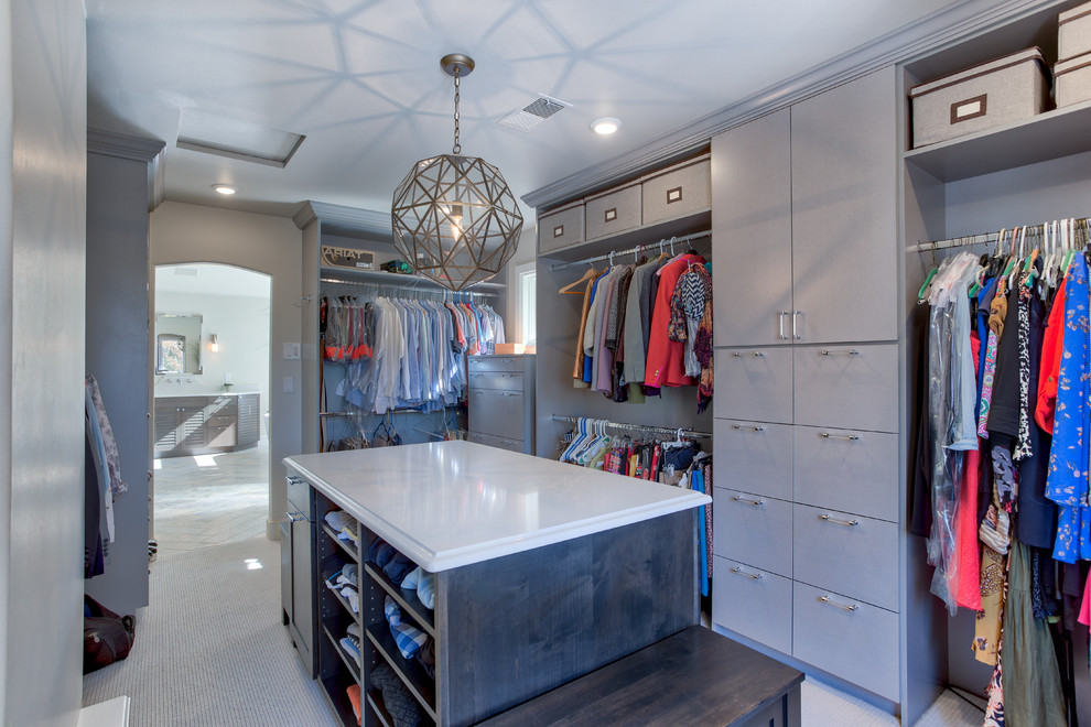 Photo of an expansive beach style gender-neutral dressing room in Denver with louvered cabinets, medium wood cabinets and ceramic floors.