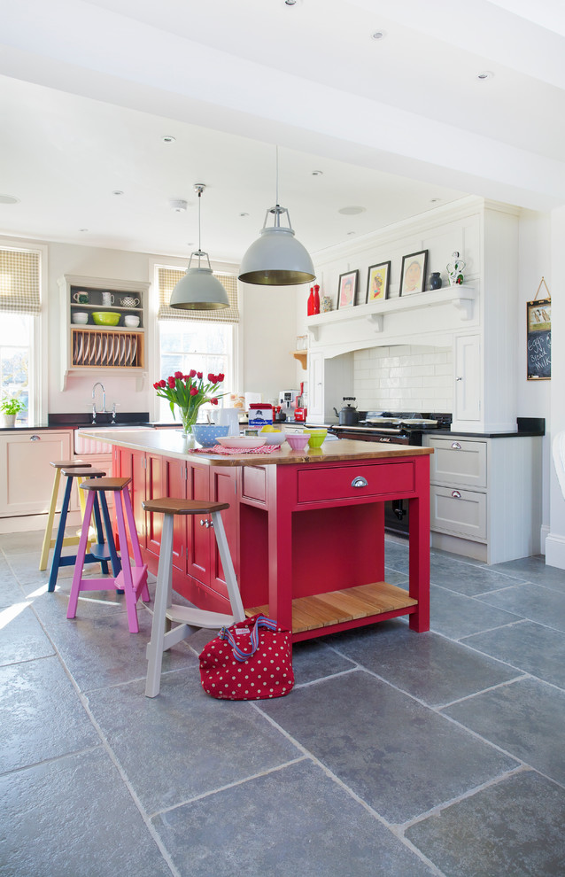 Transitional kitchen in Kent with red cabinets, wood benchtops, white splashback, subway tile splashback and with island.