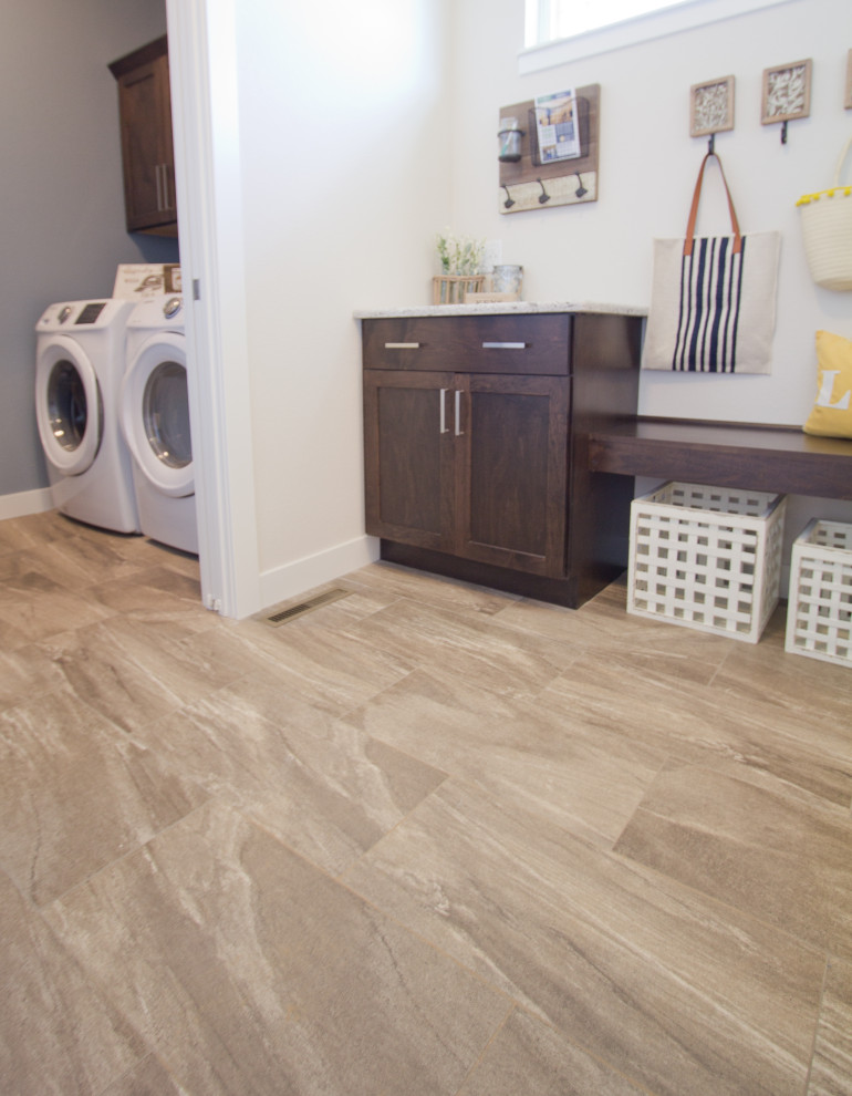 This is an example of a traditional utility room in Other with vinyl floors, a side-by-side washer and dryer and brown floor.