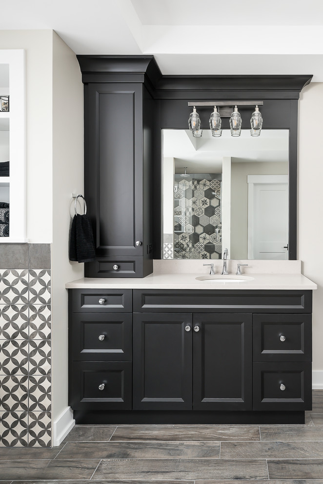 Large transitional master bathroom in Chicago with shaker cabinets, black cabinets, a freestanding tub, black and white tile, mosaic tile, grey walls, ceramic floors, an undermount sink, engineered quartz benchtops, brown floor, a hinged shower door, white benchtops and a corner shower.