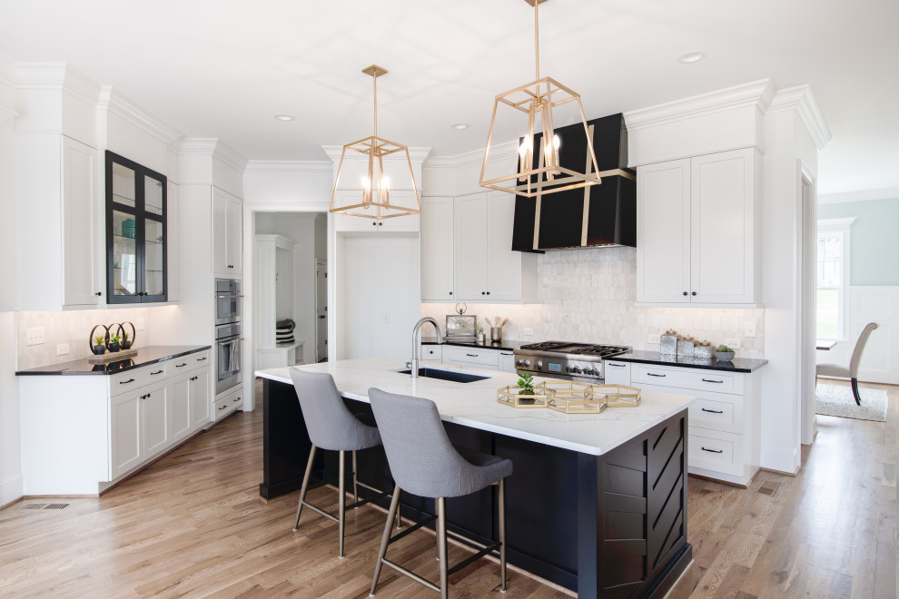 This is an example of a transitional eat-in kitchen in Other with shaker cabinets, white splashback, with island, white cabinets and white benchtop.