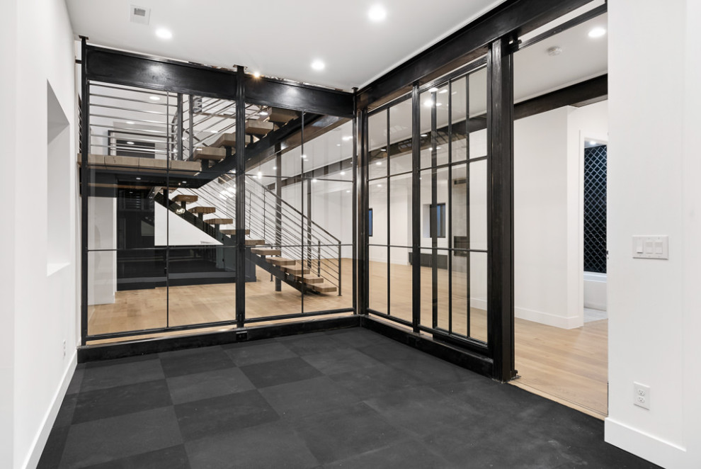 Inspiration for a large industrial multipurpose gym in Denver with white walls and black floor.