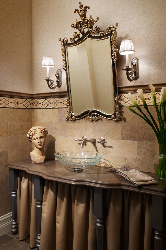 Design ideas for a mid-sized mediterranean powder room in Miami with a vessel sink, beige walls, furniture-like cabinets, dark wood cabinets, beige tile, ceramic tile, ceramic floors, marble benchtops, brown floor and brown benchtops.
