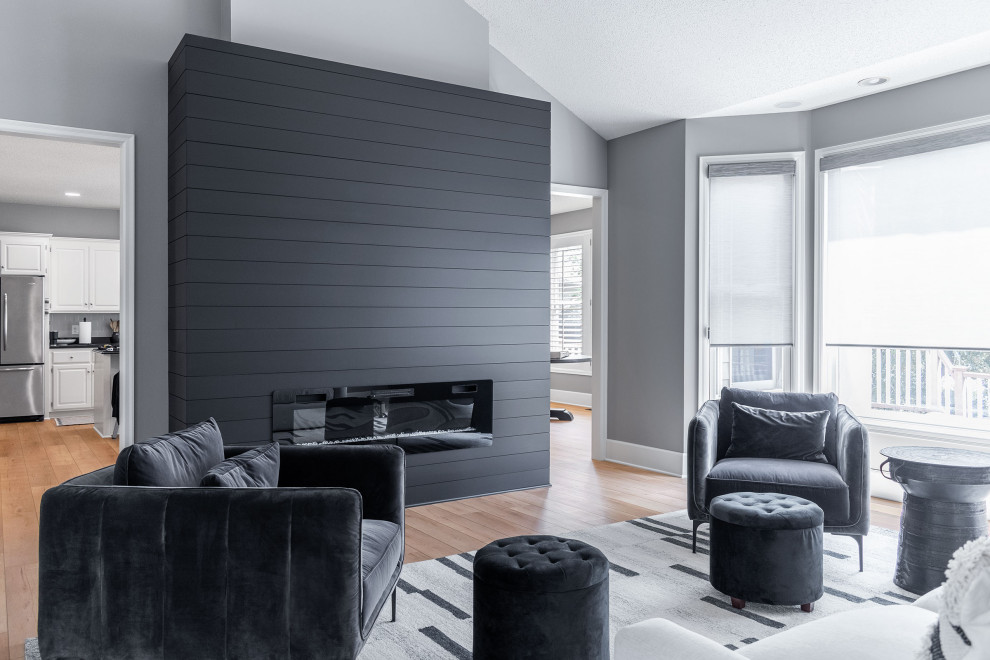 Mittelgroßes, Repräsentatives, Offenes Modernes Wohnzimmer mit weißer Wandfarbe, Kamin und Kaminumrandung aus Holzdielen in Minneapolis