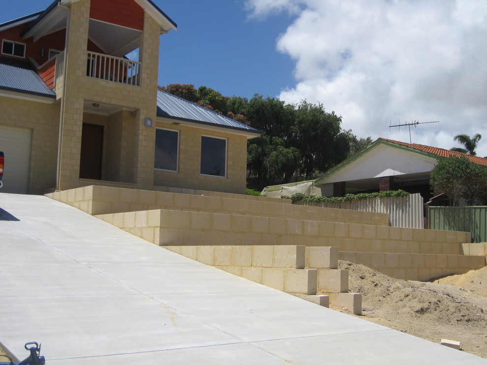Mid-sized contemporary front yard full sun driveway in Perth with a retaining wall for summer.