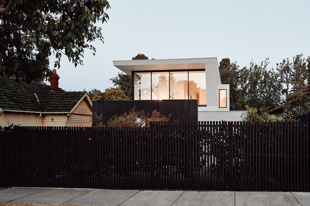 Design ideas for a large contemporary two-storey white house exterior in Melbourne with wood siding, a flat roof and a metal roof.