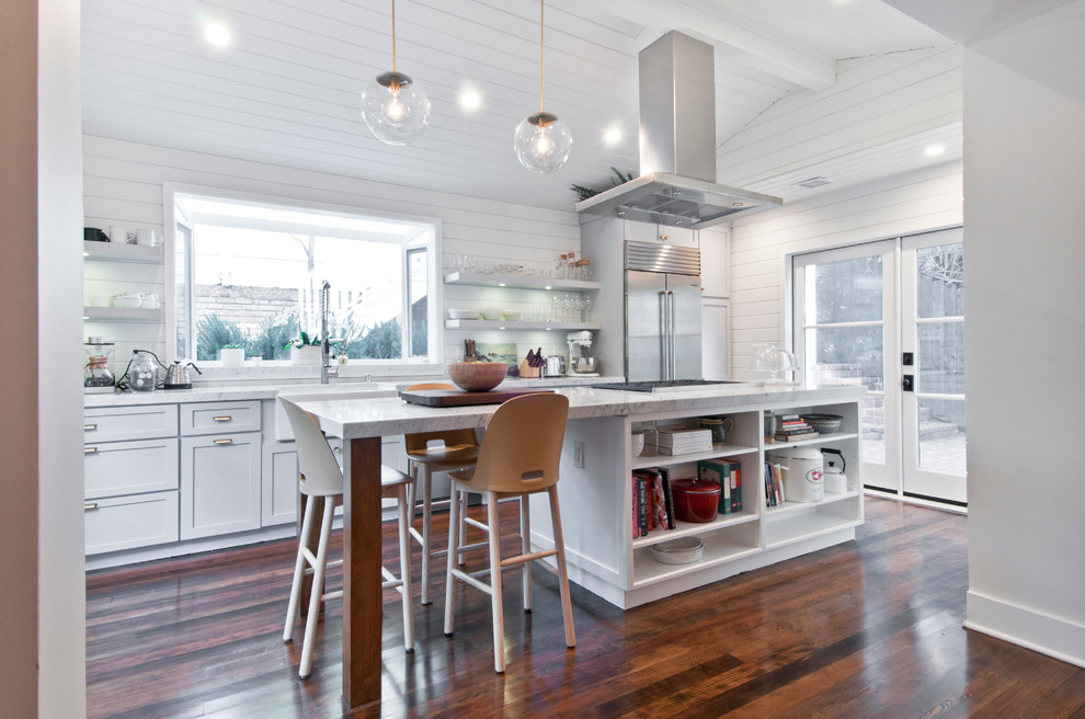 Inspiration for a mid-sized country galley eat-in kitchen in Los Angeles with a farmhouse sink, shaker cabinets, white cabinets, marble benchtops, white splashback, timber splashback, stainless steel appliances, painted wood floors and with island.