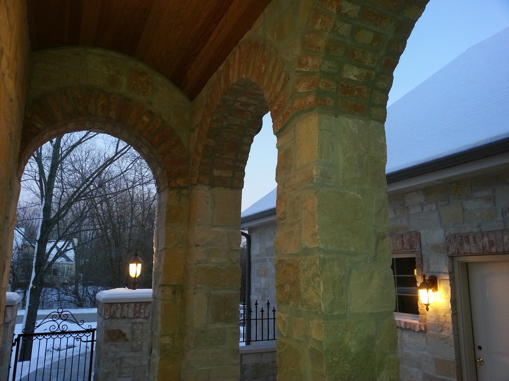 Inspiration for a large country one-storey beige exterior in Milwaukee with stone veneer and a gable roof.