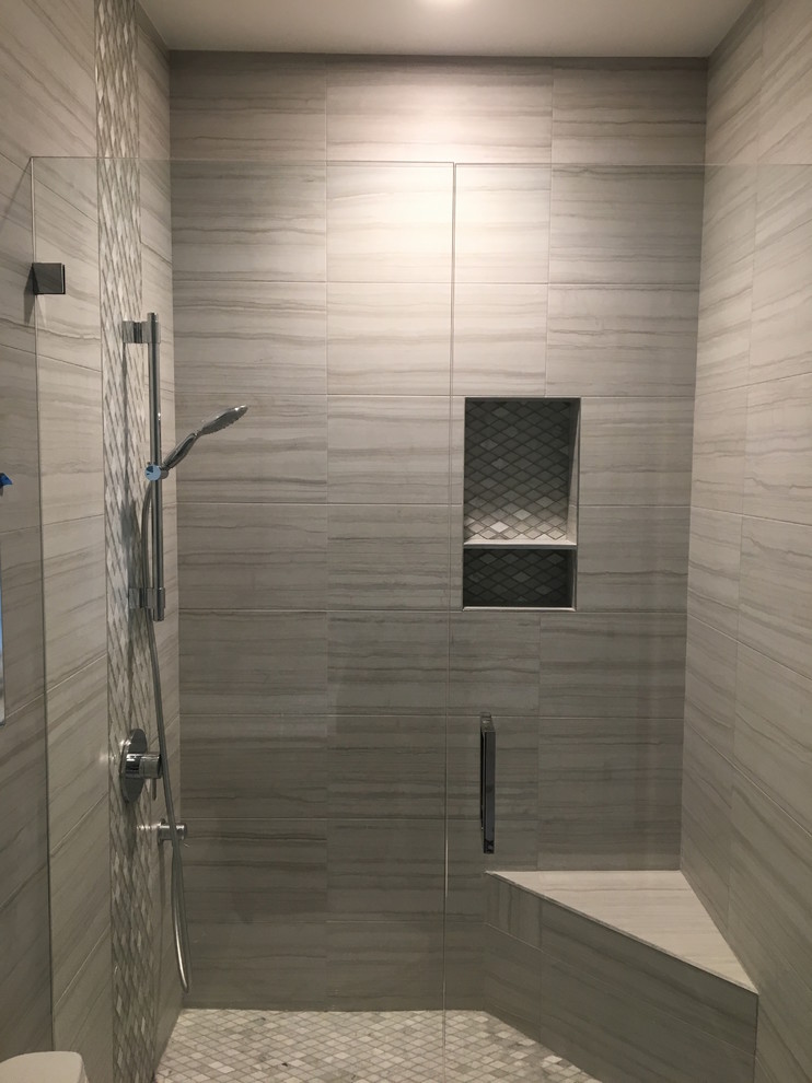 This is an example of a large transitional master bathroom in Orange County with flat-panel cabinets, dark wood cabinets, glass tile, an integrated sink, a hinged shower door, a freestanding tub, a corner shower, white walls, ceramic floors and beige floor.