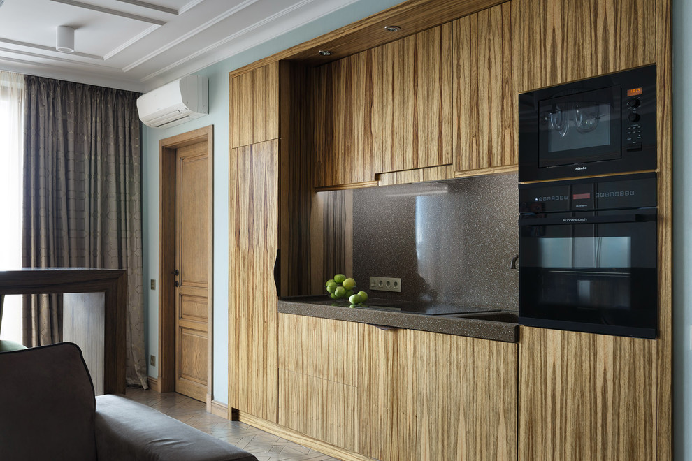 Design ideas for a contemporary single-wall open plan kitchen in Saint Petersburg with flat-panel cabinets, medium wood cabinets, black splashback, black appliances, medium hardwood floors and no island.