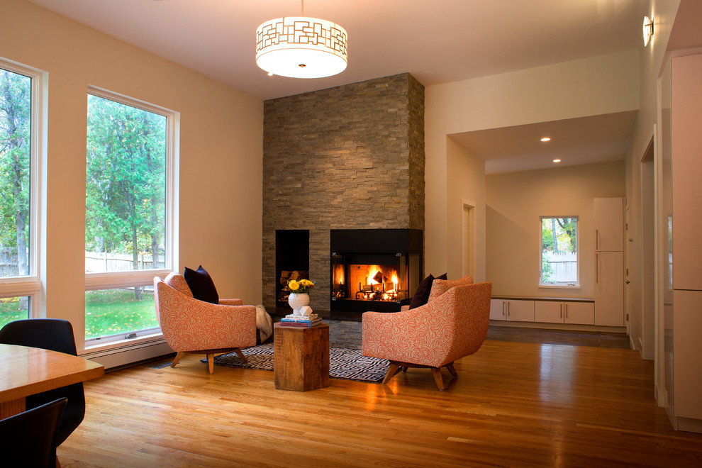 Photo of a mid-sized midcentury open concept family room in Denver with white walls, light hardwood floors, a corner fireplace and a stone fireplace surround.