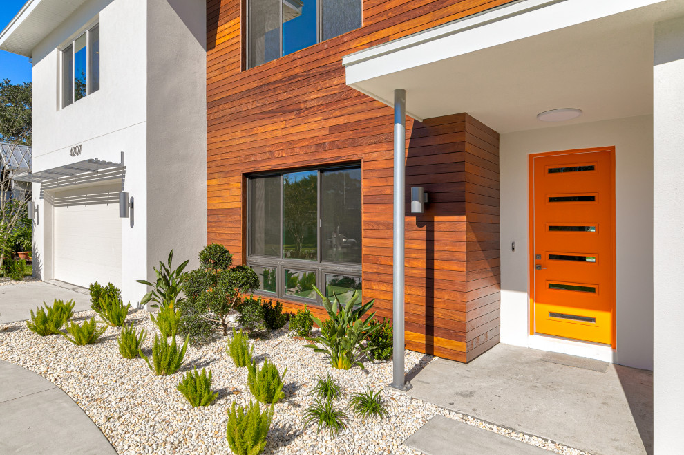 Diseño de fachada de casa blanca y marrón minimalista grande de dos plantas con revestimiento de estuco y tejado de teja de madera