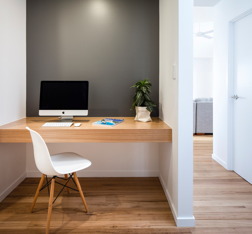This is an example of a small contemporary study room in Sunshine Coast with grey walls, medium hardwood floors, a built-in desk and beige floor.