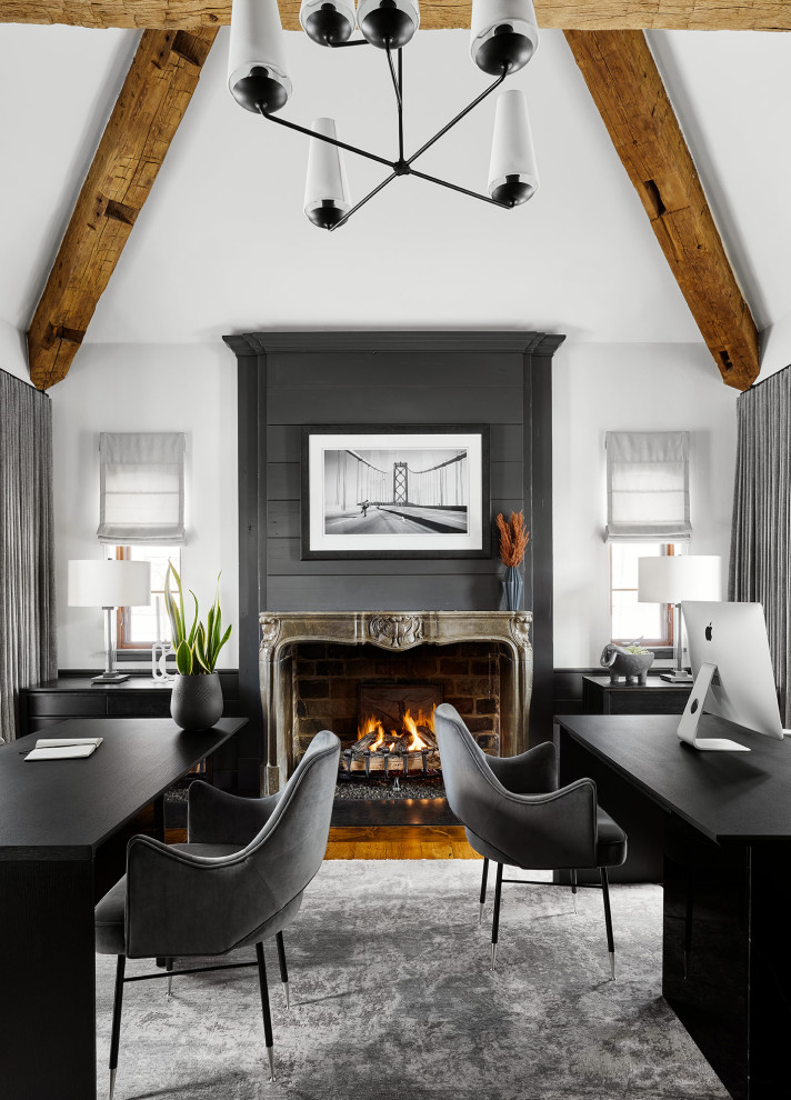 Exemple d'un grand bureau tendance avec un mur blanc, un sol en bois brun, une cheminée standard, un manteau de cheminée en bois, un bureau indépendant et un plafond voûté.