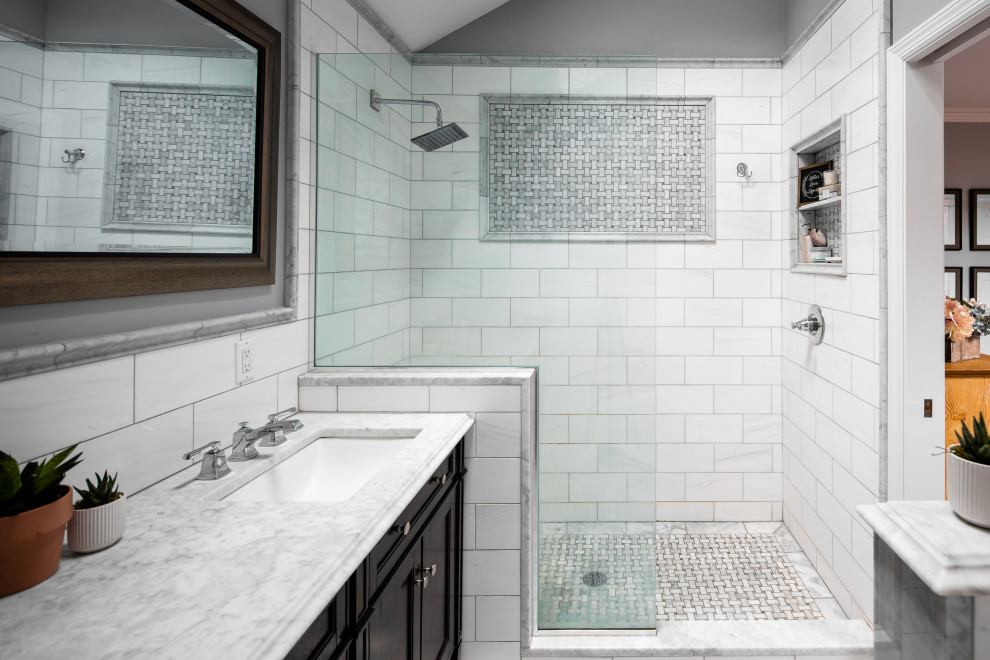 Photo of a medium sized contemporary shower room bathroom in New York with shaker cabinets, black cabinets, a walk-in shower, a two-piece toilet, white tiles, porcelain tiles, grey walls, a submerged sink, marble worktops, an open shower, white worktops, double sinks, a built in vanity unit and a vaulted ceiling.