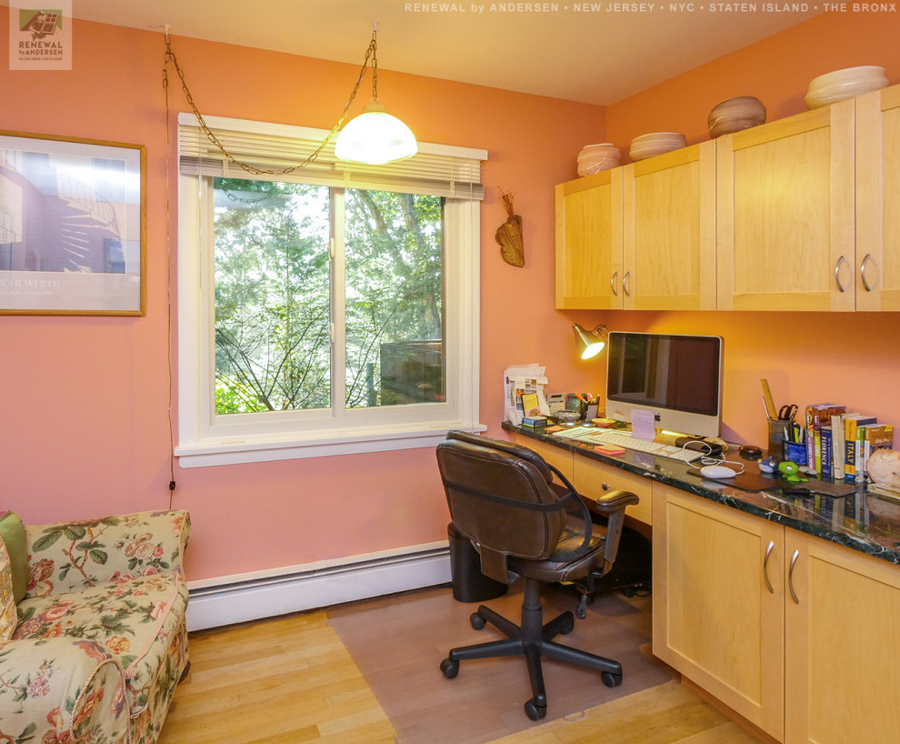 Exempel på ett mellanstort arbetsrum, med orange väggar, ljust trägolv, ett inbyggt skrivbord och beiget golv