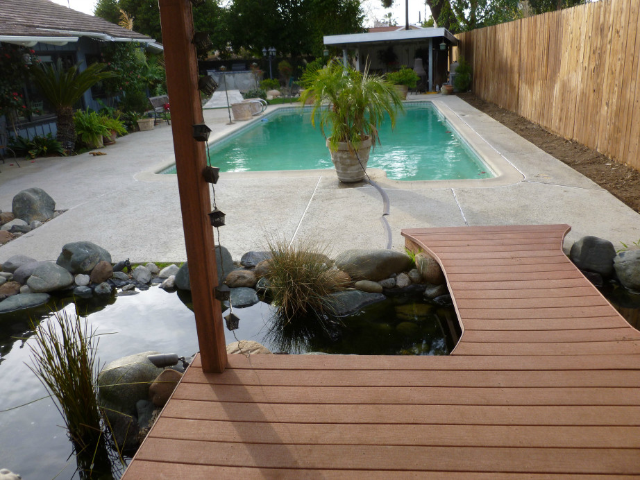 This is an example of a mid-sized modern backyard partial sun garden in Los Angeles with a water feature and natural stone pavers.