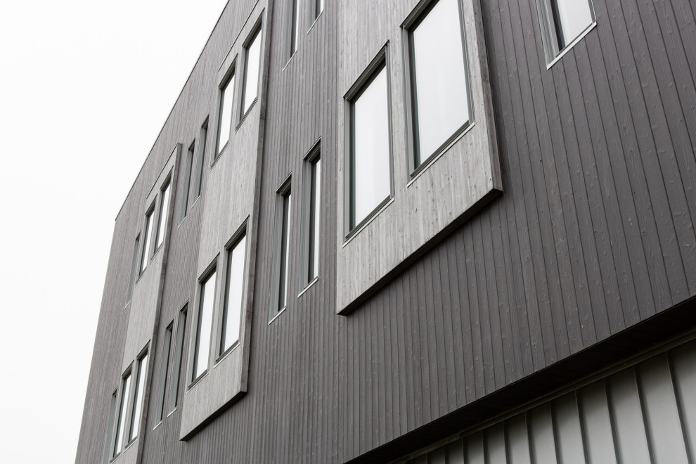 Photo of an expansive industrial black exterior in Other with four or more storeys and wood siding.