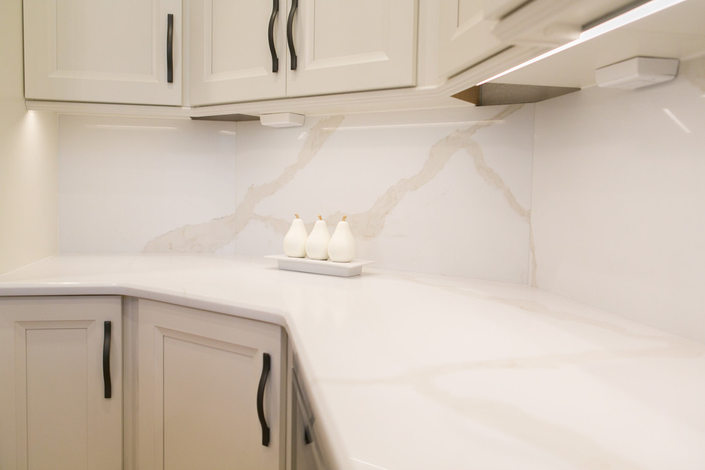 Mid-sized transitional u-shaped open concept kitchen photo in Orlando with recessed-panel cabinets, white cabinets, quartzite countertops, white backsplash, stone slab backsplash, stainless steel appliances and a peninsula