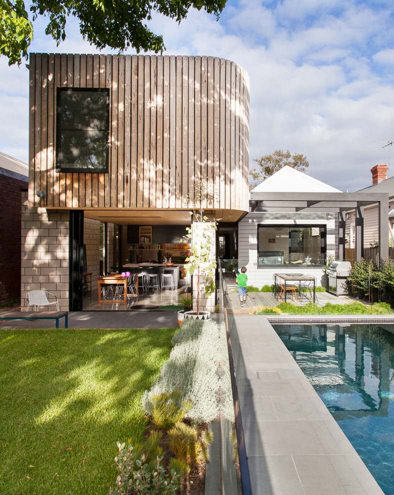 Photo of a contemporary two-storey exterior in Melbourne with wood siding and a flat roof.