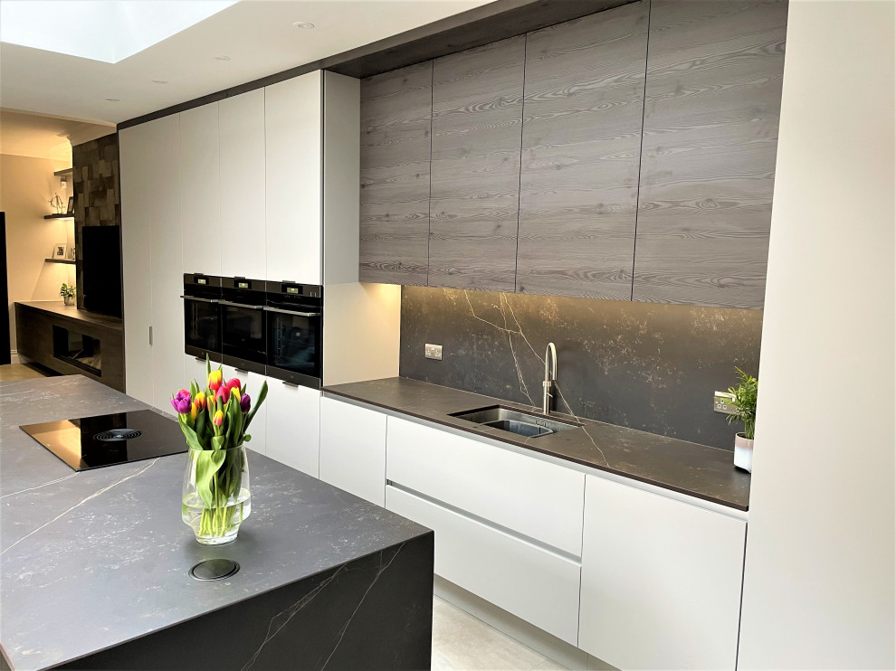 Inspiration for a large contemporary grey and brown single-wall open plan kitchen in Other with a single-bowl sink, flat-panel cabinets, medium wood cabinets, engineered stone countertops, grey splashback, black appliances, vinyl flooring, an island, grey floors, grey worktops and a chimney breast.