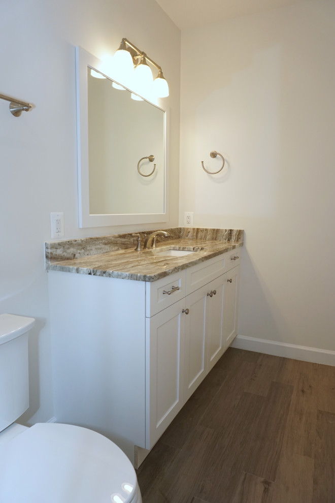 Inspiration for a mid-sized transitional kids bathroom in DC Metro with recessed-panel cabinets, white cabinets, an alcove shower, a two-piece toilet, white tile, porcelain tile, white walls, porcelain floors, an undermount sink, granite benchtops, grey floor, a sliding shower screen and multi-coloured benchtops.