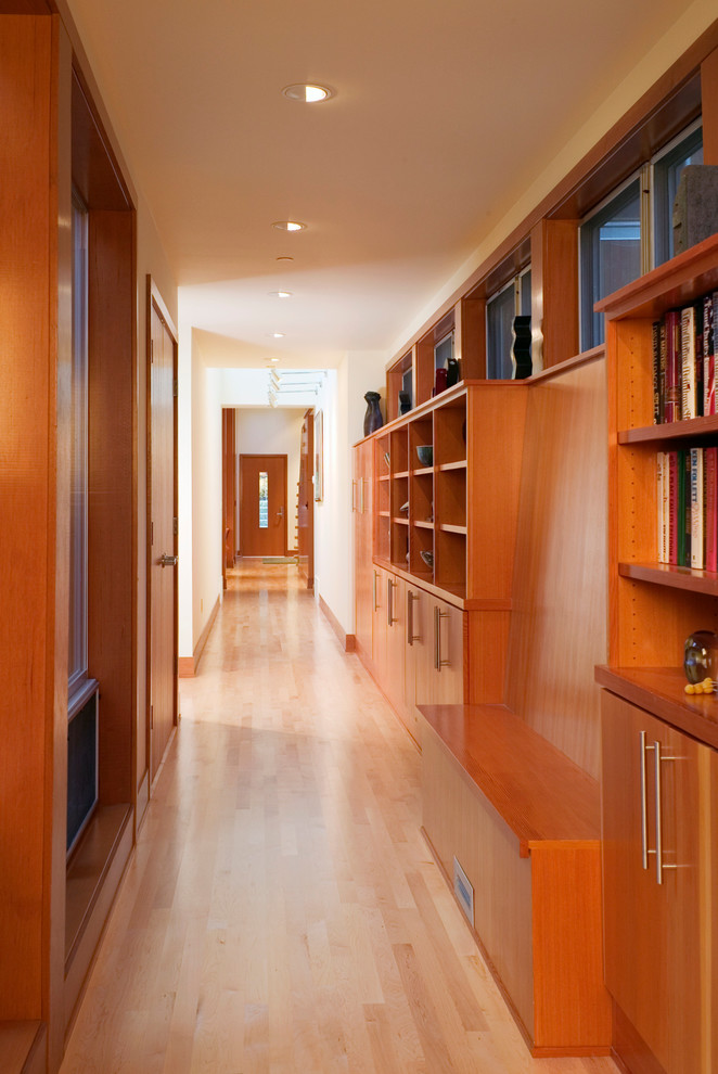 This is an example of a contemporary hallway in Seattle with light hardwood floors and beige walls.