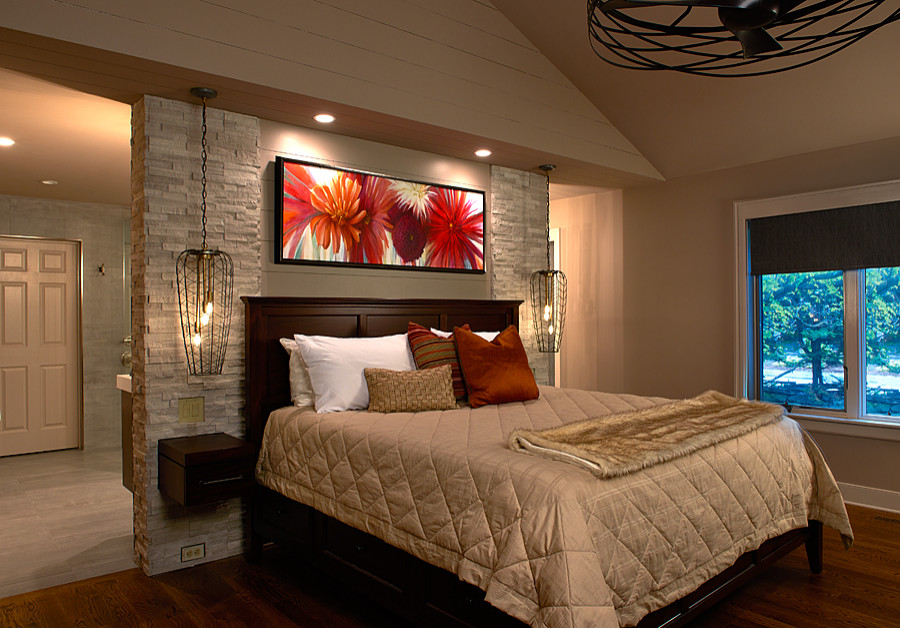 Aménagement d'une chambre parentale moderne avec un mur beige, un sol en bois brun, un sol marron et un plafond voûté.