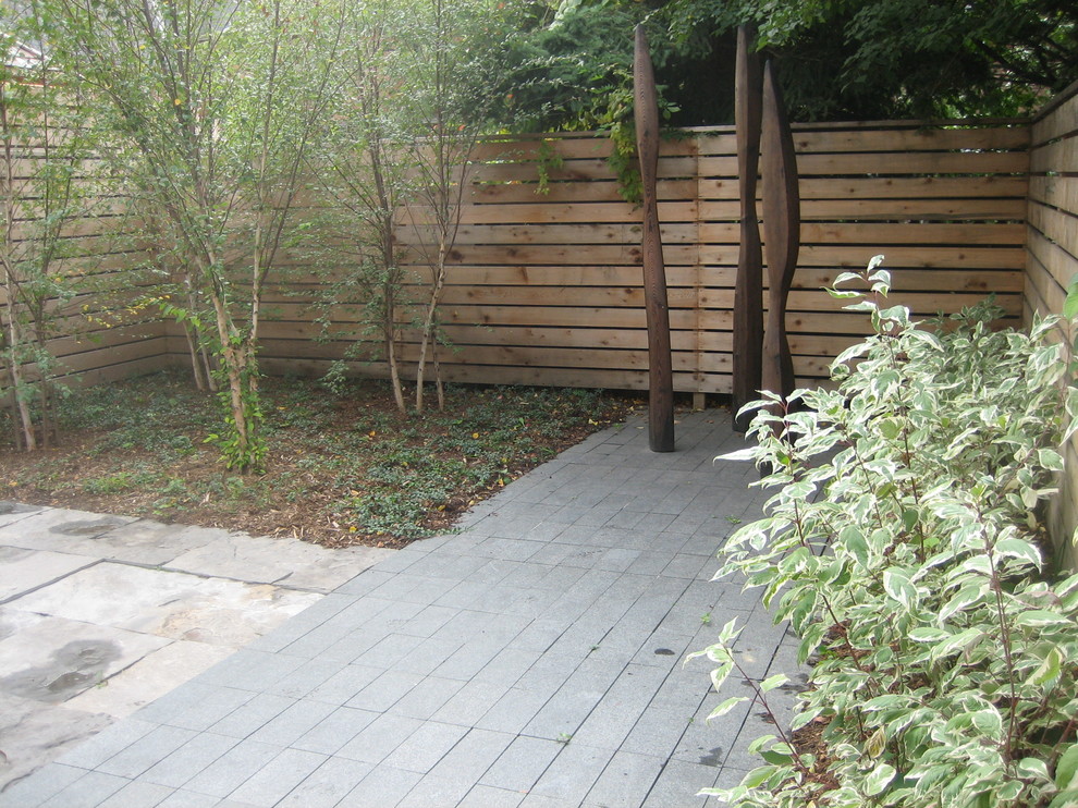 Photo of a small transitional front yard partial sun driveway for summer in Toronto with a garden path and natural stone pavers.