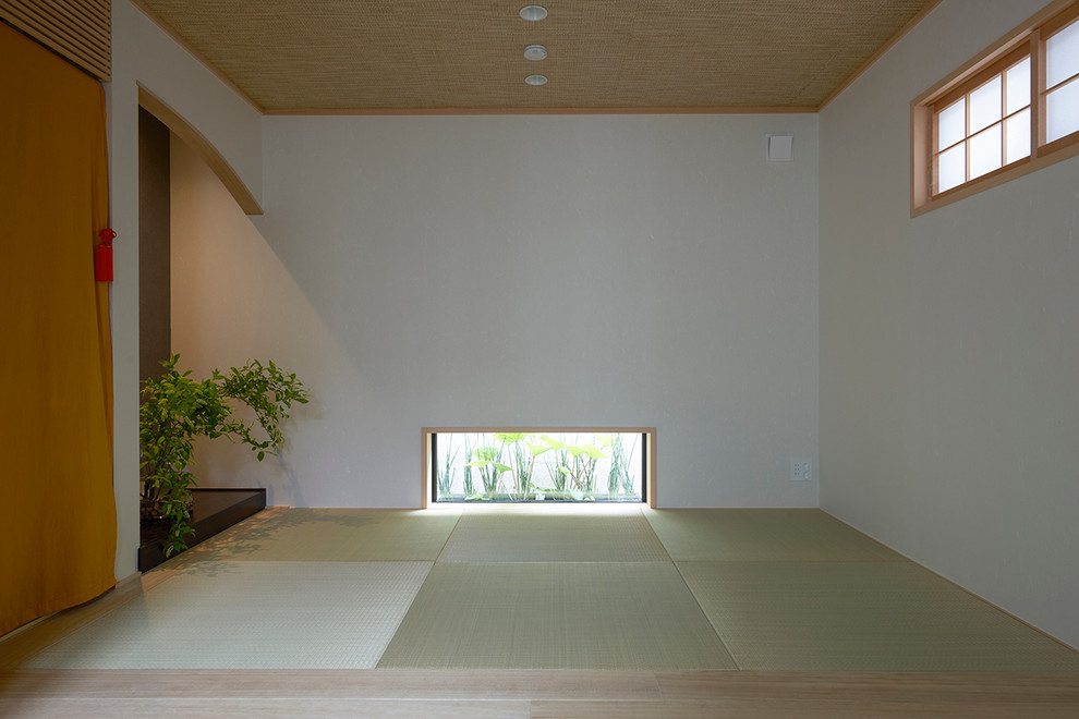 This is an example of a small asian enclosed family room in Tokyo with white walls, no fireplace and no tv.