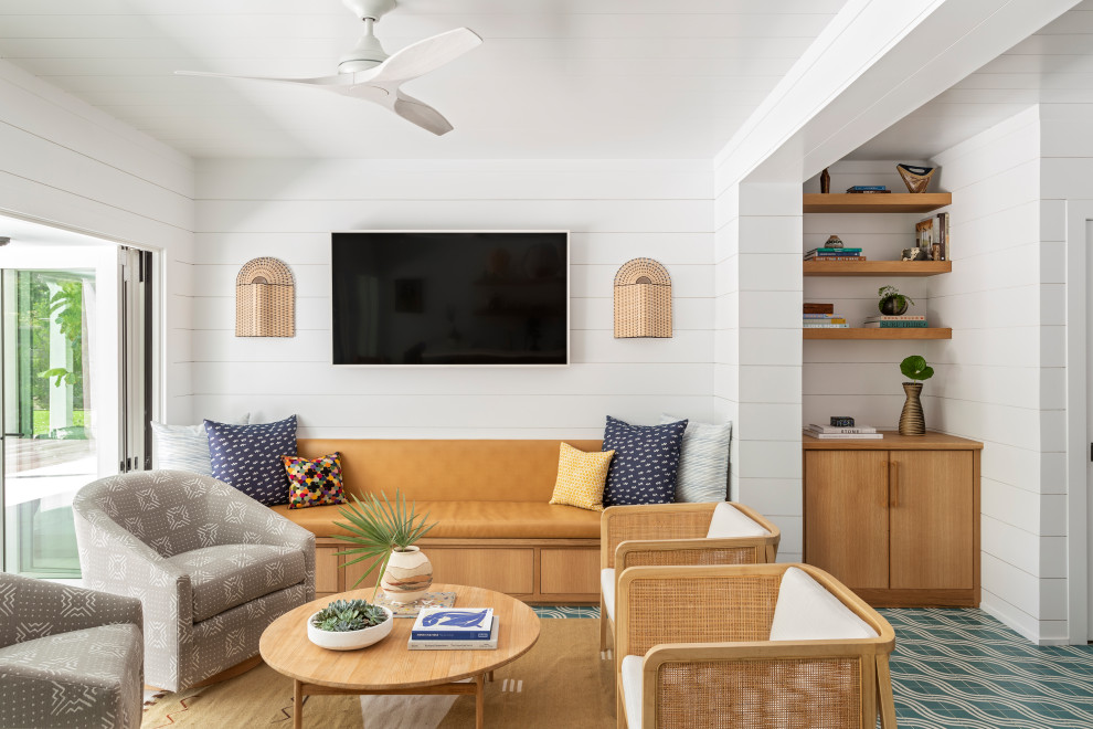 Maritimes Wohnzimmer mit weißer Wandfarbe, TV-Wand, blauem Boden und Holzdielenwänden in Charleston