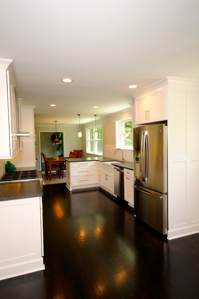 Eat-in kitchen - mid-sized transitional galley dark wood floor eat-in kitchen idea in DC Metro with a farmhouse sink, shaker cabinets, white cabinets, granite countertops, white backsplash, subway tile backsplash, stainless steel appliances and a peninsula