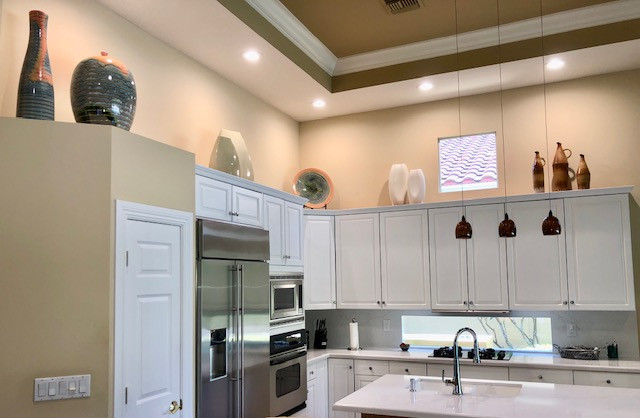 Open concept kitchen - mid-sized transitional open concept kitchen idea with a double-bowl sink, white cabinets, quartz countertops, white backsplash, quartz backsplash, an island and yellow countertops