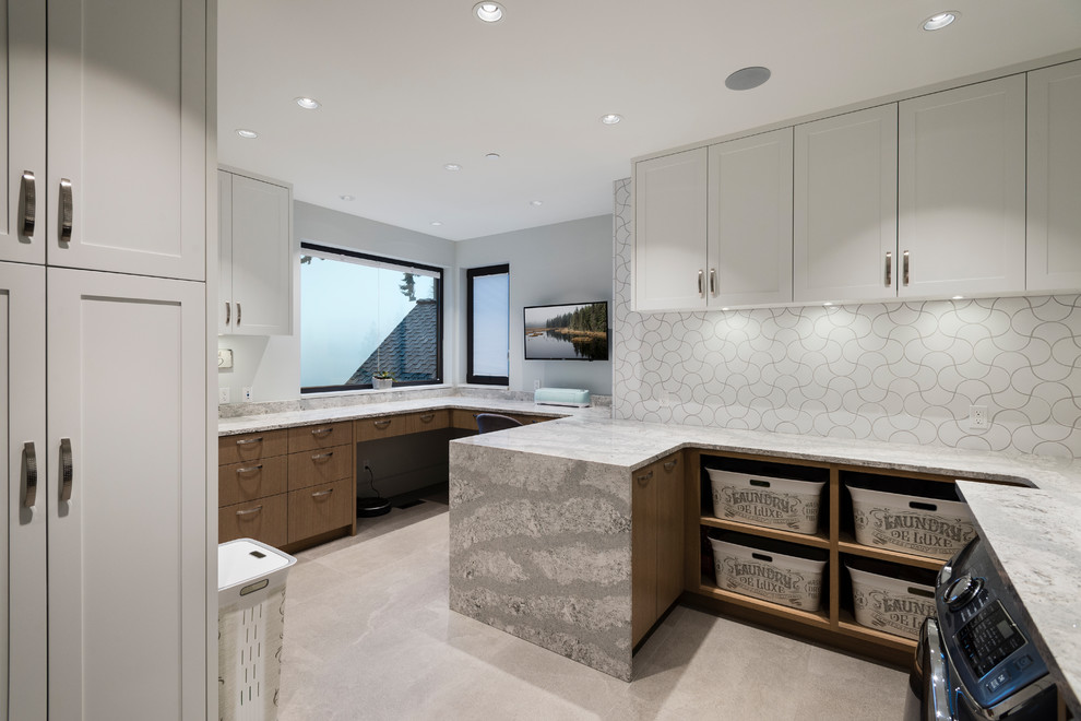 Design ideas for an expansive transitional u-shaped dedicated laundry room in Vancouver with flat-panel cabinets, porcelain floors, a side-by-side washer and dryer, grey floor, grey benchtop, quartzite benchtops, white walls and white cabinets.