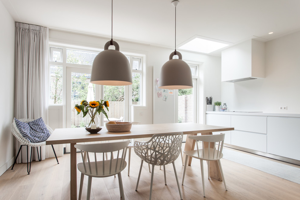 Photo of a scandinavian dining room in Amsterdam with white walls, light hardwood floors and no fireplace.