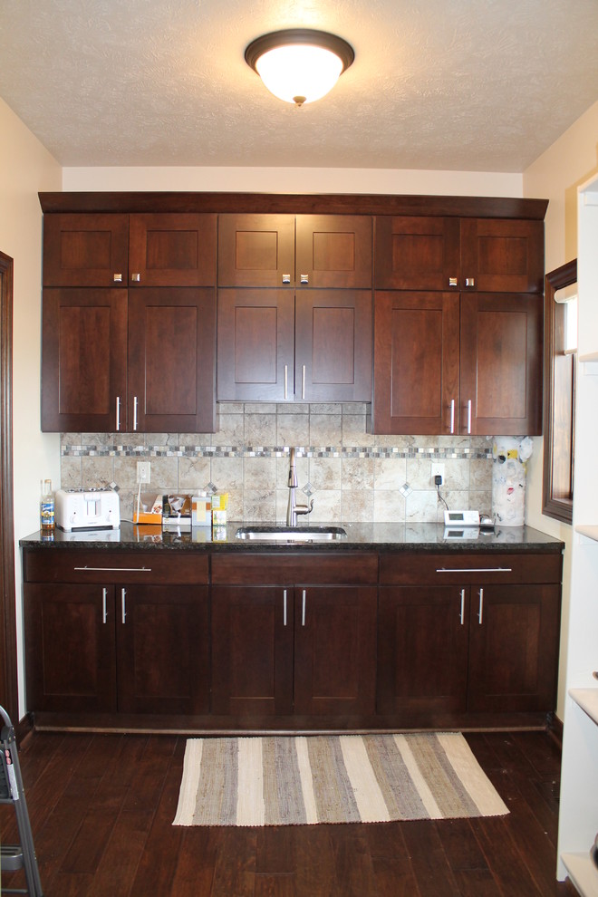 Example of a large single-wall dark wood floor open concept kitchen design with an undermount sink, flat-panel cabinets, dark wood cabinets, granite countertops, beige backsplash, stainless steel appliances, beige walls and two islands