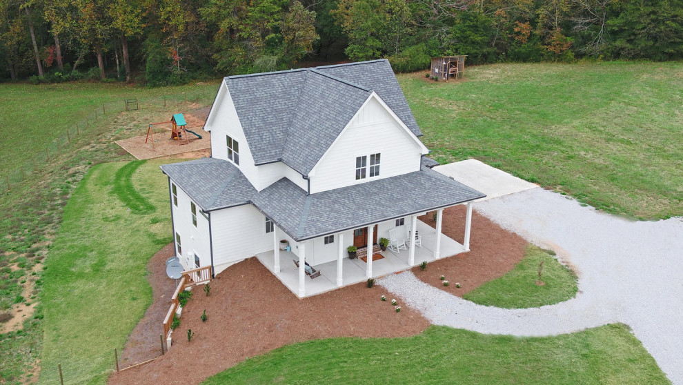This is an example of a mid-sized country two-storey white house exterior in Atlanta with a shingle roof.