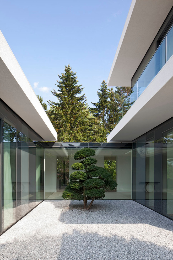 This is an example of a mid-sized contemporary two-storey exterior in Stuttgart with a flat roof.