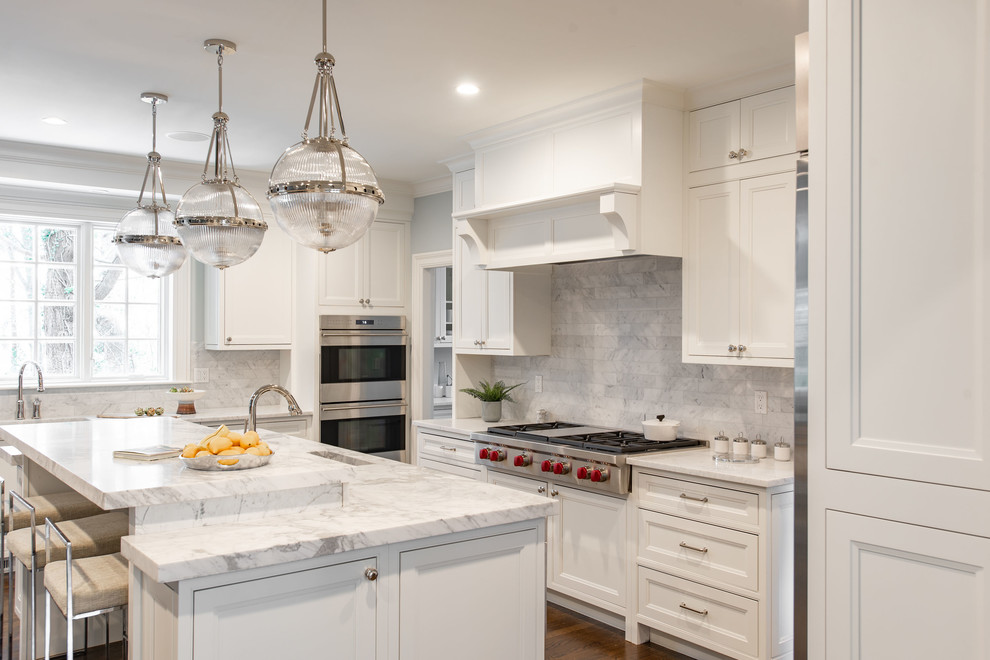 Expansive traditional l-shaped eat-in kitchen in Boston with an undermount sink, beaded inset cabinets, white cabinets, marble benchtops, grey splashback, marble splashback, stainless steel appliances, dark hardwood floors, with island, brown floor and white benchtop.