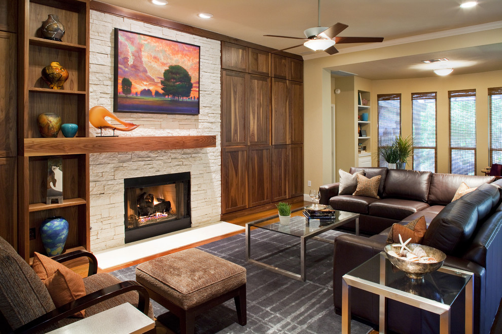 This is an example of a contemporary living room in Austin with a standard fireplace and a stone fireplace surround.
