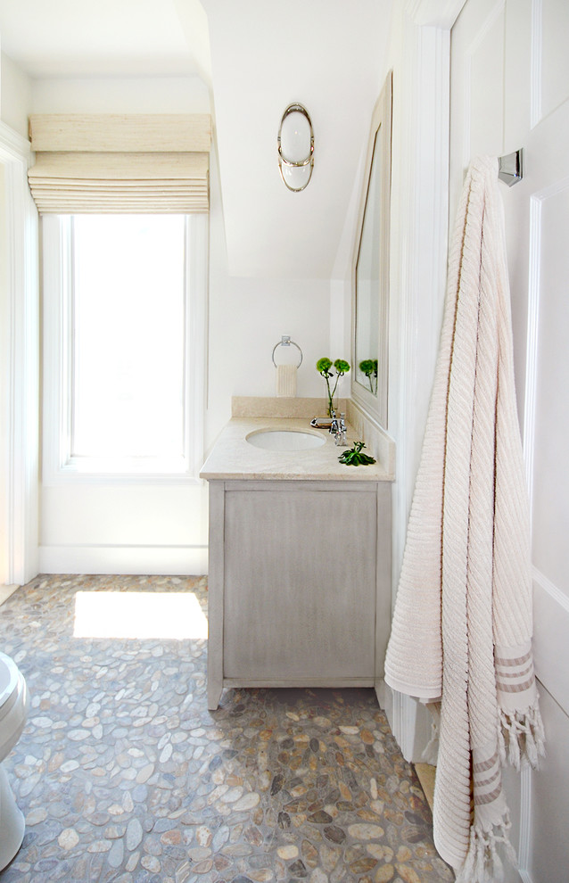 Inspiration for a mid-sized beach style kids bathroom in Bridgeport with an undermount sink, distressed cabinets, marble benchtops, an alcove tub, a shower/bathtub combo, a one-piece toilet, multi-coloured tile, pebble tile, white walls and pebble tile floors.