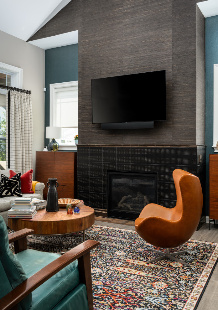 Photo of a mid-sized traditional loft-style living room in Cincinnati with ceramic floors, a standard fireplace, a tile fireplace surround, vaulted and wallpaper.
