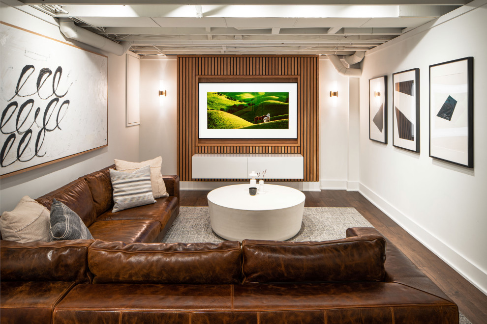 Cette photo montre un sous-sol moderne en bois enterré et de taille moyenne avec salle de cinéma, un mur blanc, un sol en vinyl et un sol marron.