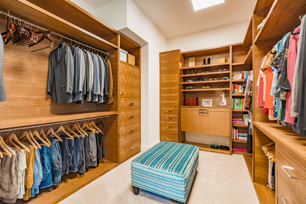 Large contemporary gender-neutral walk-in wardrobe in Austin with flat-panel cabinets, carpet, beige floor and medium wood cabinets.