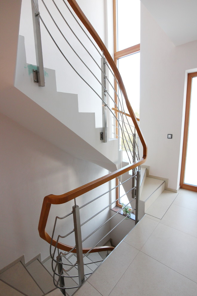 Mid-sized contemporary curved staircase in Dresden with mixed railing.