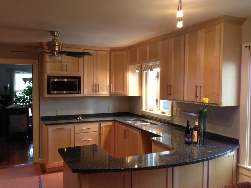 Enclosed kitchen - small transitional u-shaped medium tone wood floor enclosed kitchen idea in Chicago with a double-bowl sink, shaker cabinets, light wood cabinets, quartzite countertops, stainless steel appliances and a peninsula